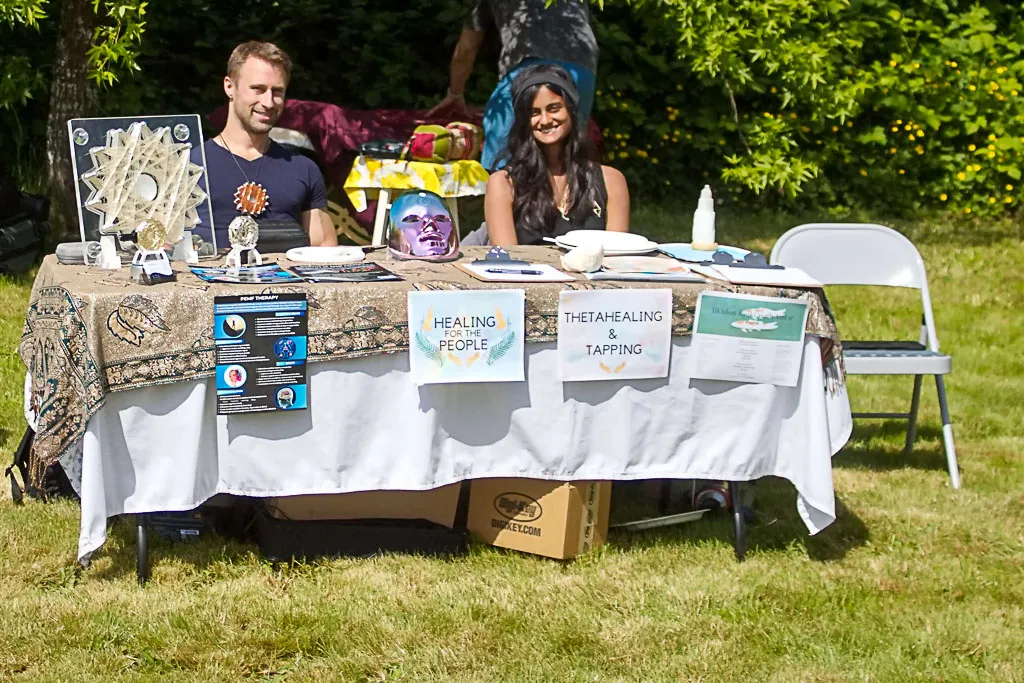 People at the Thetahealing booth during a past festival